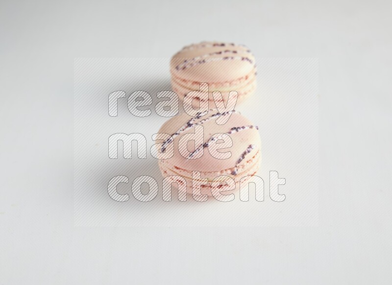 45º Shot of two pink orange blossom macarons on white background