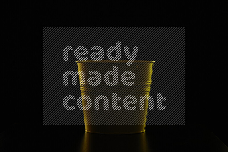 A plant pot with colored rim light against black background