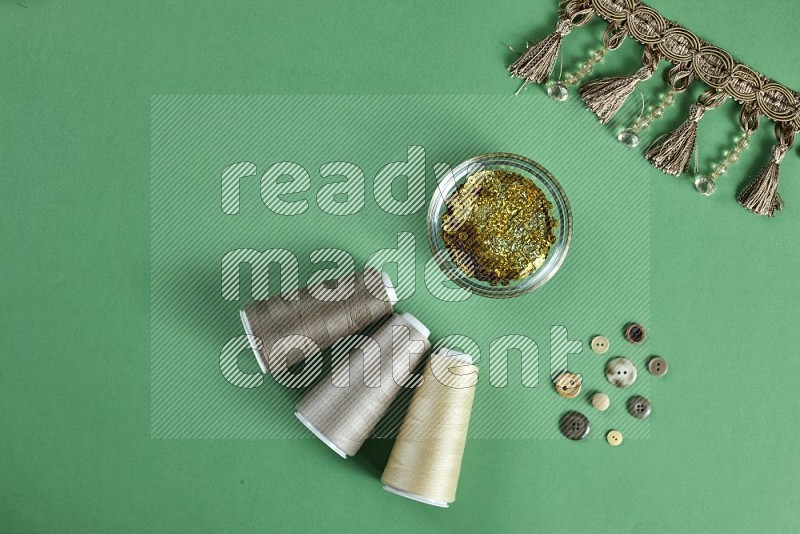 Brown sewing supplies on green background