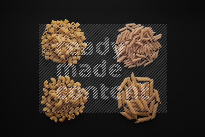 Different pasta types in bunches on black background