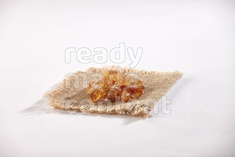 Gum arabic on a burlap piece on white flooring in different angles