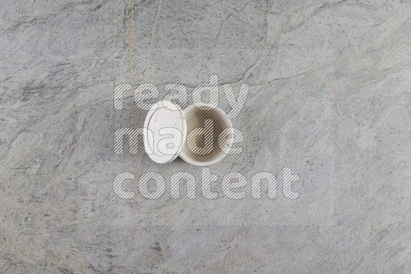 Top View Shot Of A Multicolored Pottery Cup On Grey Marble Flooring