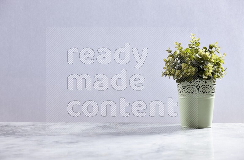 Artificial plant in green decorative pot on grey marble background
