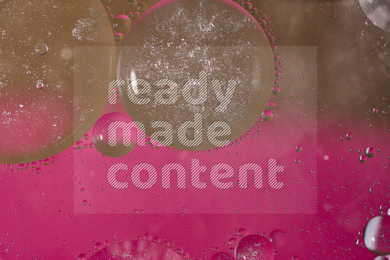 لقطات مقربة لفقاعات من الزيت على سطح الماء باللون الوردي والبني