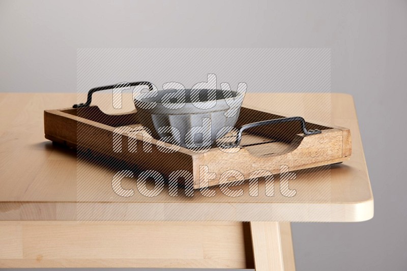 grey bowl on a light colored rectangular wooden tray with handles