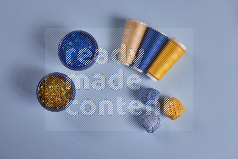 A yellow and blue collection of sewing and tailoring tools arranged on a blue background