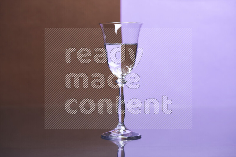 تظهر الصورة أواني زجاجية ممتلئة بالماء موضوعة على خلفية من اللونين البني والأرجواني الفاتح