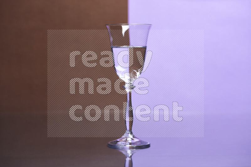 The image features a clear glassware filled with water, set against brown and light purple background