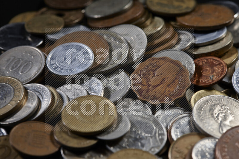 A close-ups of random old coins on black background