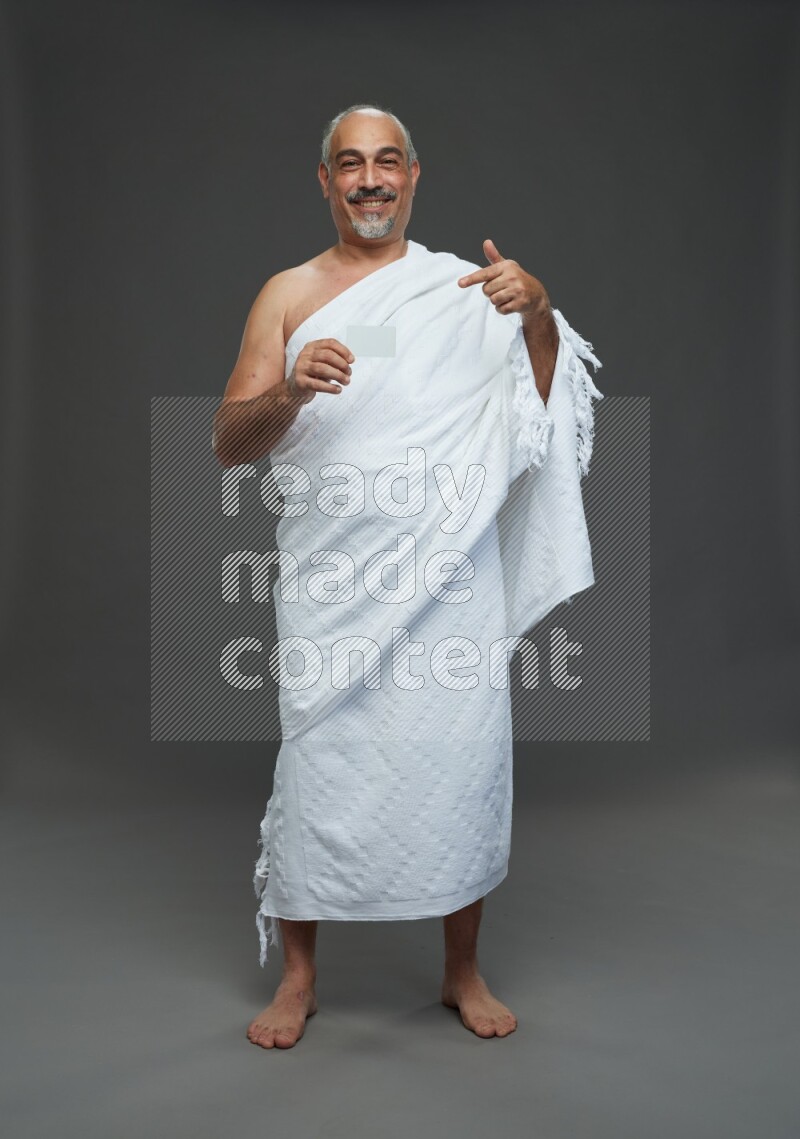 A man wearing Ehram Standing holding ATM card on gray background