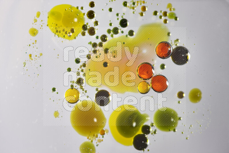 Close-ups of abstract red, green and yellow watercolor drops on oil Surface on white background