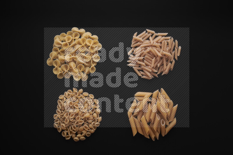 Different pasta types in bunches on black background