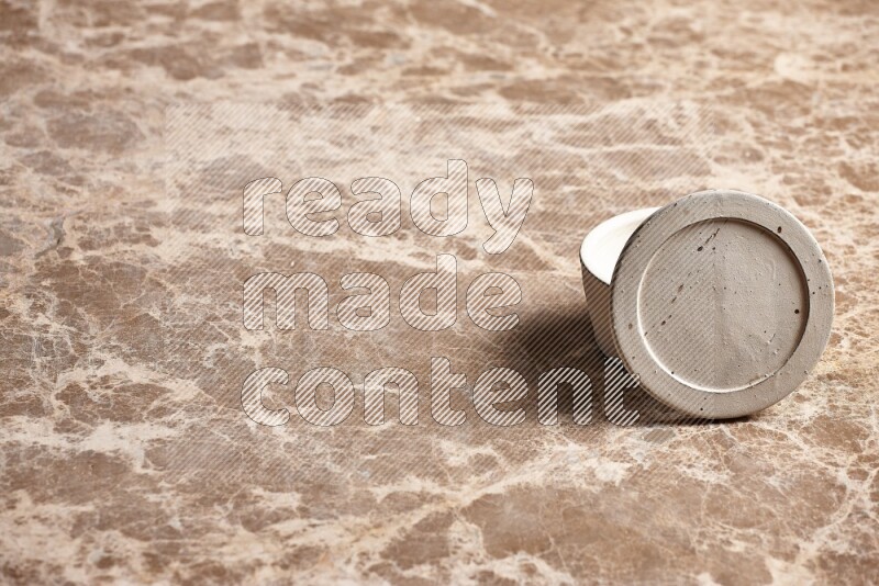 A white pottery bowl on beige marble background