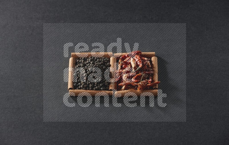 2 squares of cinnamon sticks full of chilis and black peppers on black flooring
