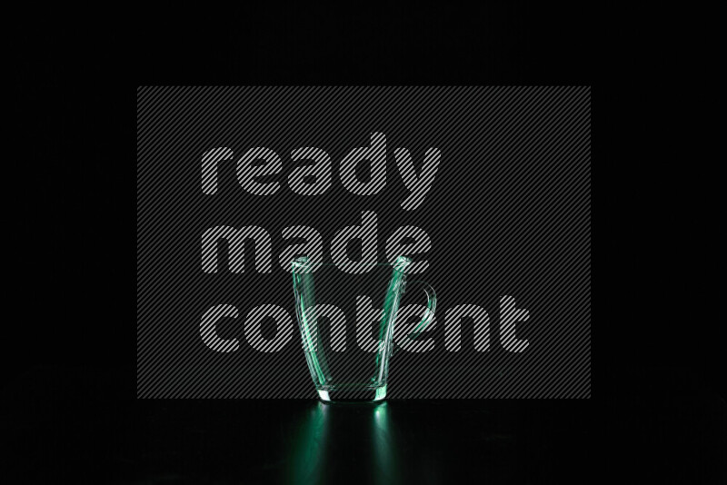 Glassware with rim light in green against black background