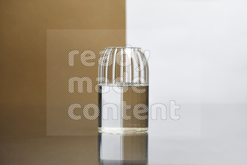 The image features a clear glassware filled with water, set against white and beige background