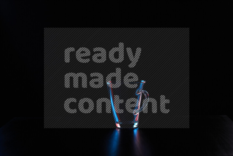 Glassware with rim light in red and blue against black background