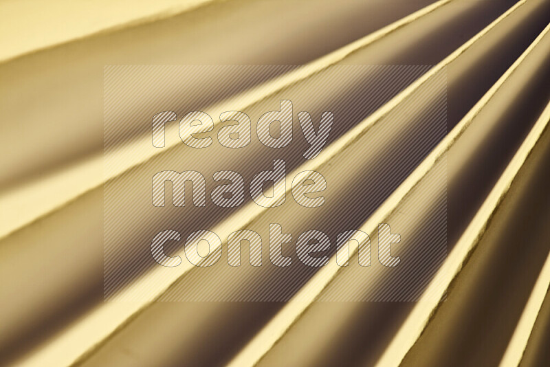 An image presenting an abstract paper pattern of lines in gold tones