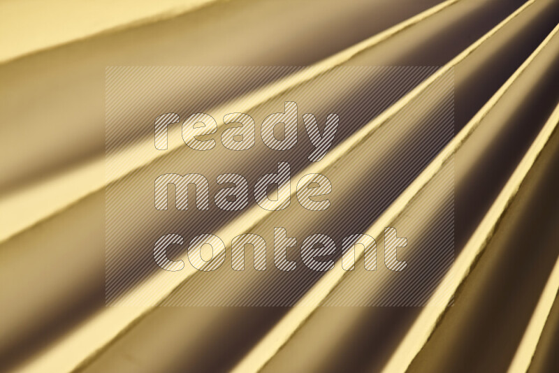 An image presenting an abstract paper pattern of lines in gold tones