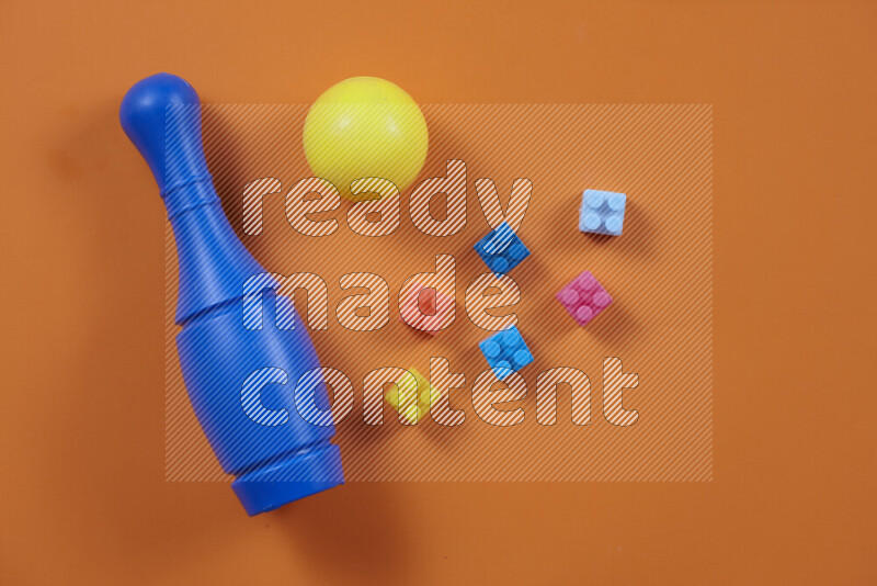 Plastic building blocks, balls and bowling pins on different colored backgrounds (kids toys)