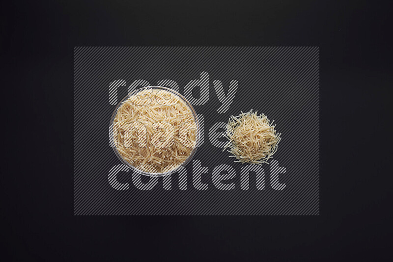 Vermicelli pasta in a glass bowl on black background