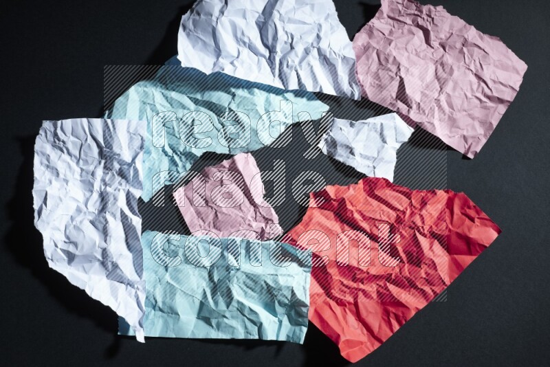 Crumpled multicolored paper on black background