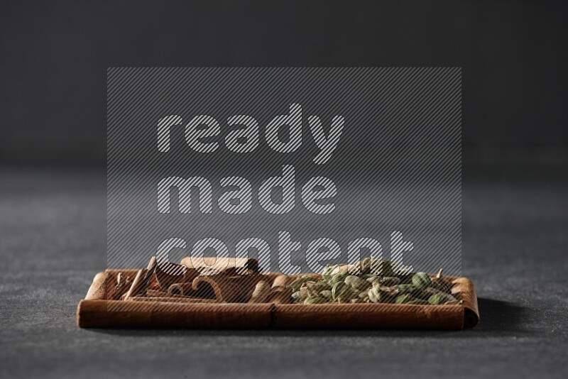 2 squares of cinnamon sticks full of cardamom and cinnamon on black flooring