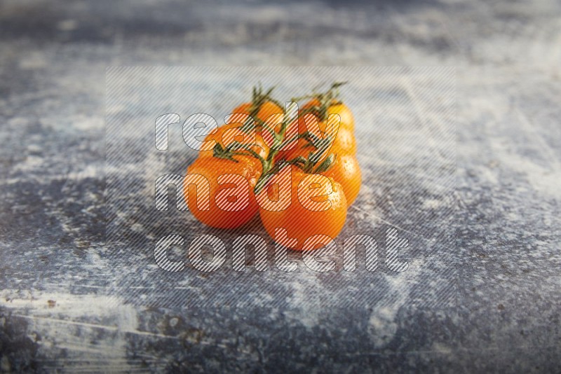 Orange cherry tomato vein on a textured rusty blue background 45 degree