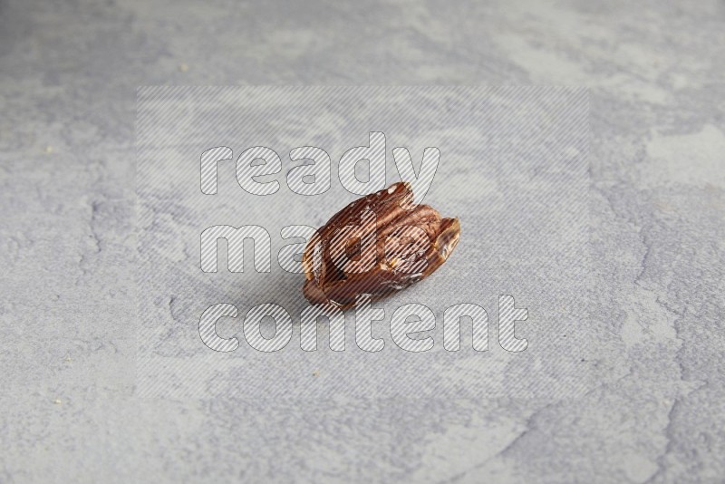 pecan stuffed date on alight grey background