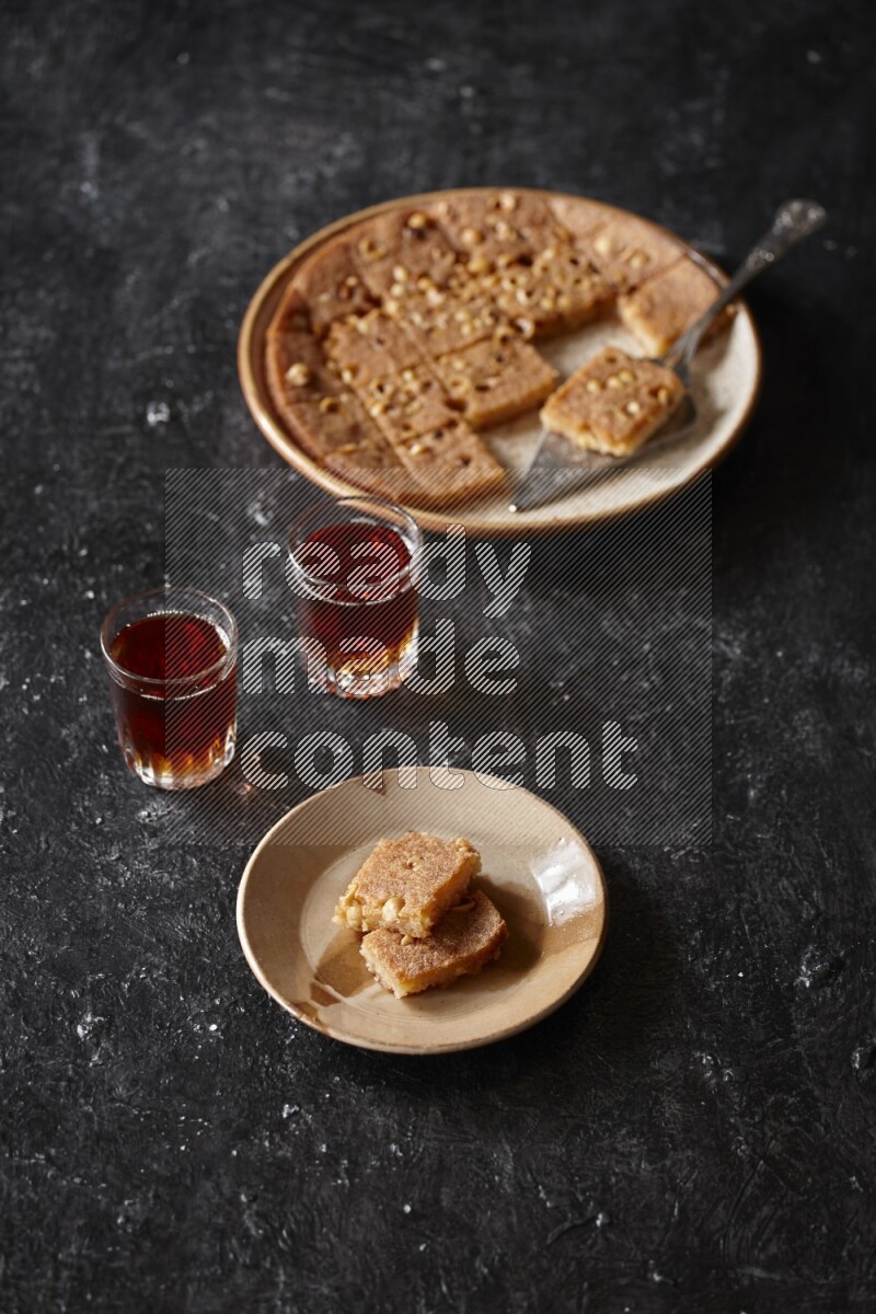 بسبوسة مع الشاي علي خلفية سوداء خشبية