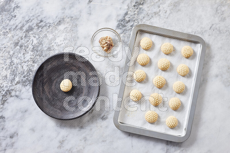 Kahk step by step with its ingredients ghee, sugar, flour, sesame, yeast, water and kahk flavor on grey marble background