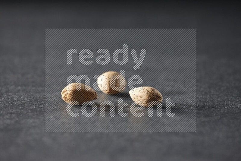 3 almonds on a black background in different angles