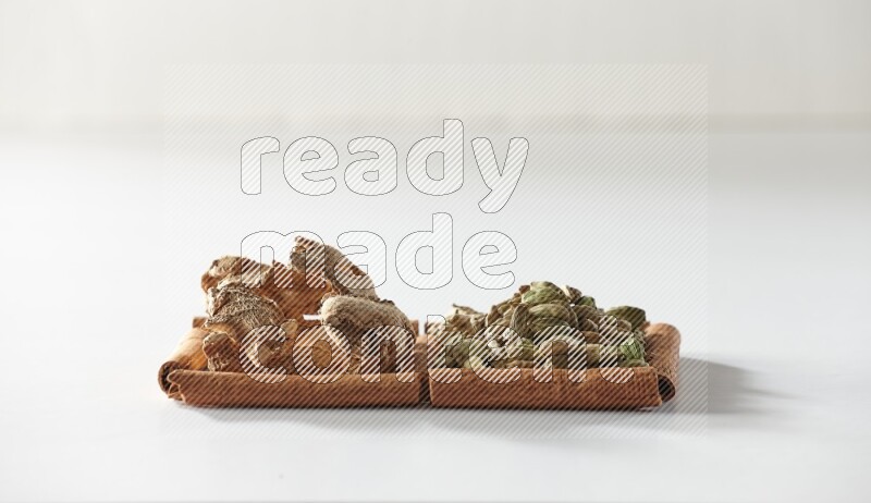 2 squares of cinnamon sticks full of cardamom and dried ginger on white flooring