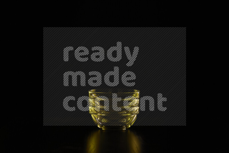 Glassware with rim light in yellow against black background