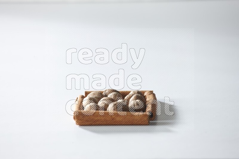 A single square of cinnamon sticks full of nutmeg on white flooring