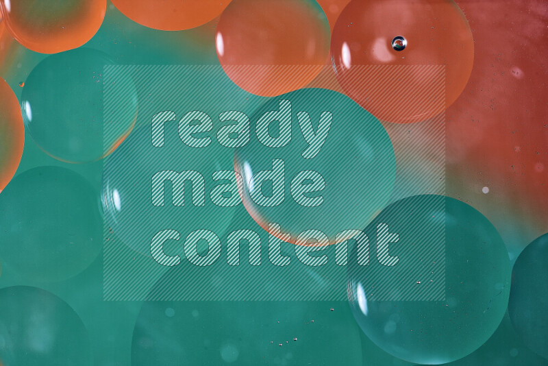 لقطات مقربة لفقاعات من الزيت على سطح الماء باللون الأخضر والبرتقالي