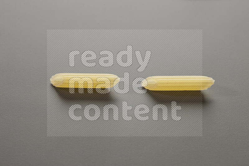 Mini penne pasta on grey background