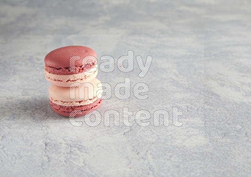 45º Shot of two Pink Litchi Raspberry macarons  on white  marble background