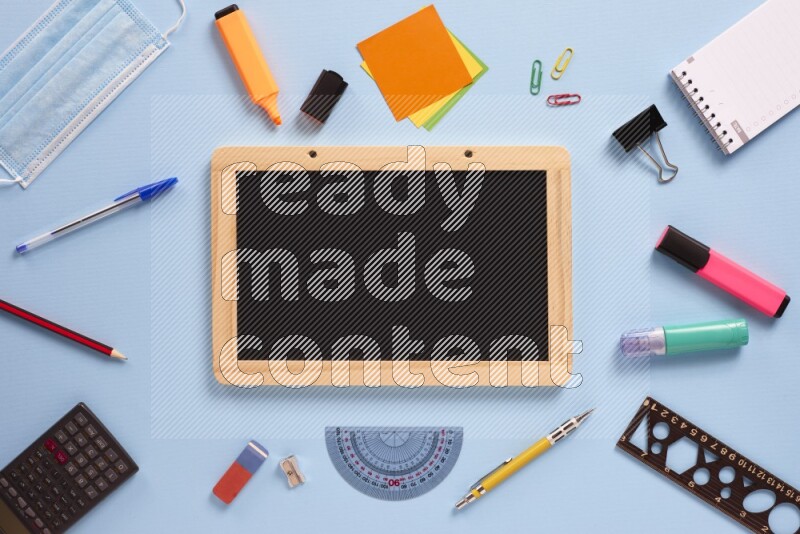 سبورة سوداء مع أدوات مدرسية مختلفة علي خلفية زرفاء