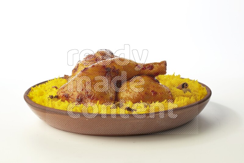 yellow basmati Rice with kabsa chicken pieces on a pottery plate direct on white background
