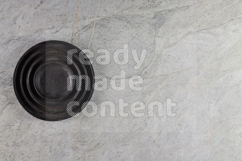 Top View Shot Of A Pottery Ripple Black Plate On Grey Marble Flooring