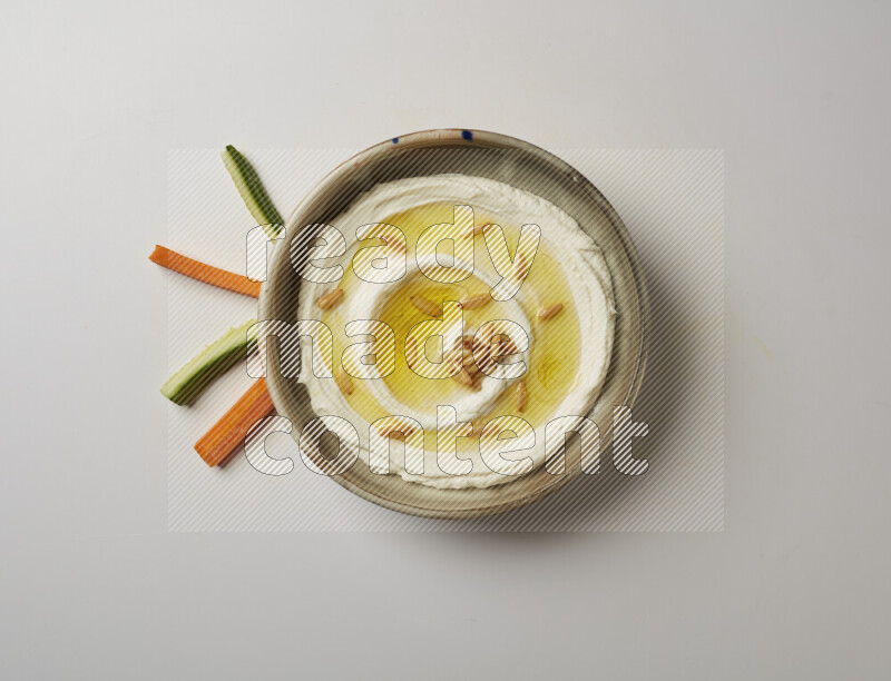 Lebnah garnished with pine nuts in a grey pottery plate on a white background