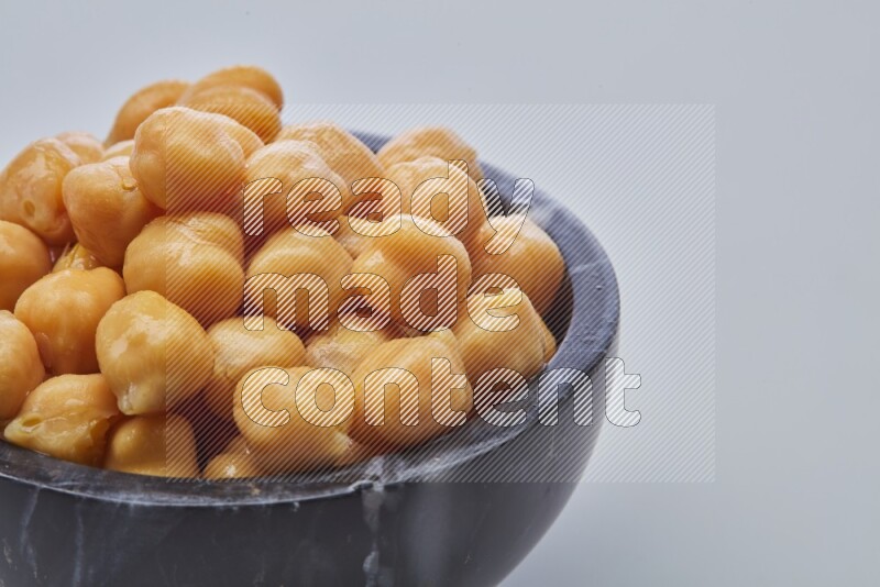 Close up of a boiled chickpeas in a container on white background