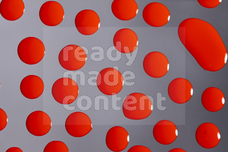 Close-ups of abstract red paint droplets on grey background