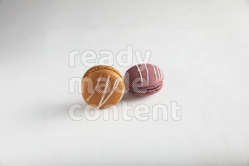 45º Shot of of two assorted Brown Irish Cream, and Red Poppy Flower macarons on white background