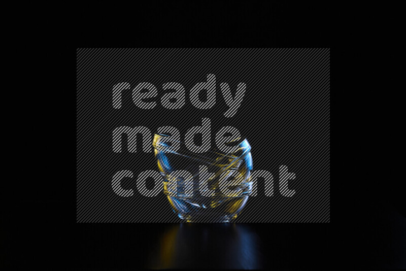 Glassware with rim light in blue and yellow against black background