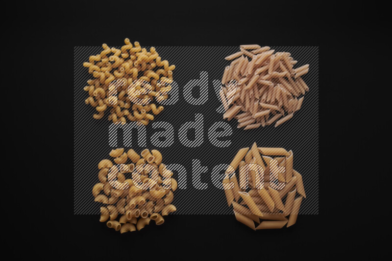 Different pasta types in bunches on black background