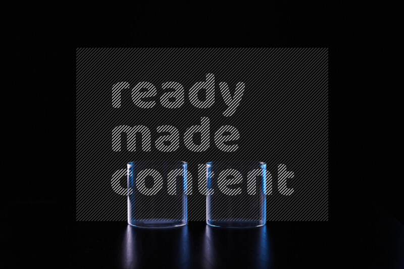 Glassware with rim light in blue and white against black background