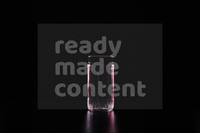 Glassware with rim light in red and white against black background