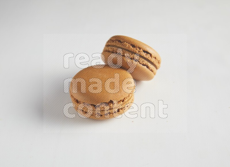 45º Shot of two Brown Maple Taffy macarons on white background